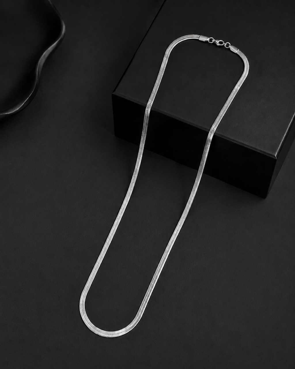 Niéche Snake Chain Necklace draped on black box