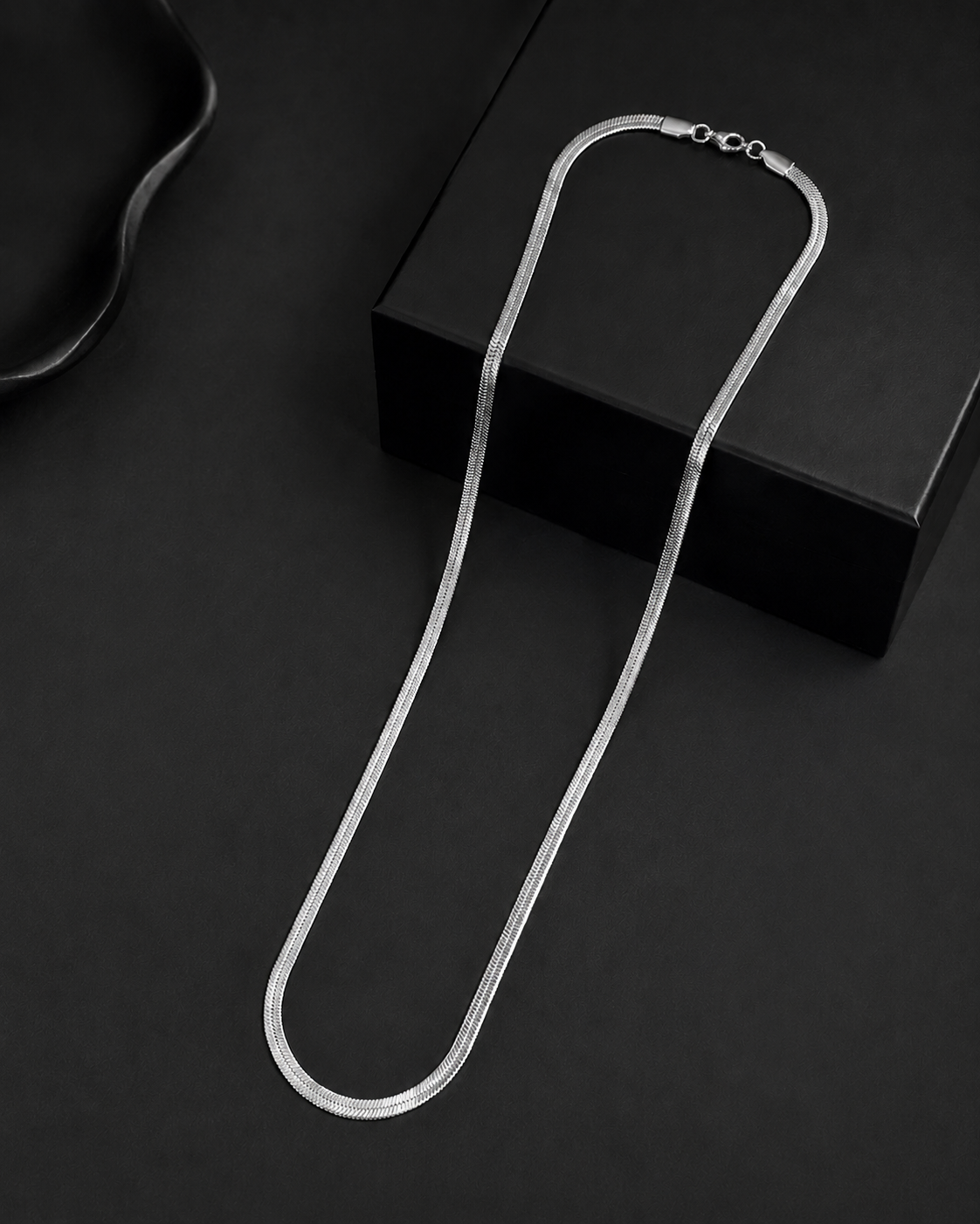 Niéche Snake Chain Necklace draped on black box