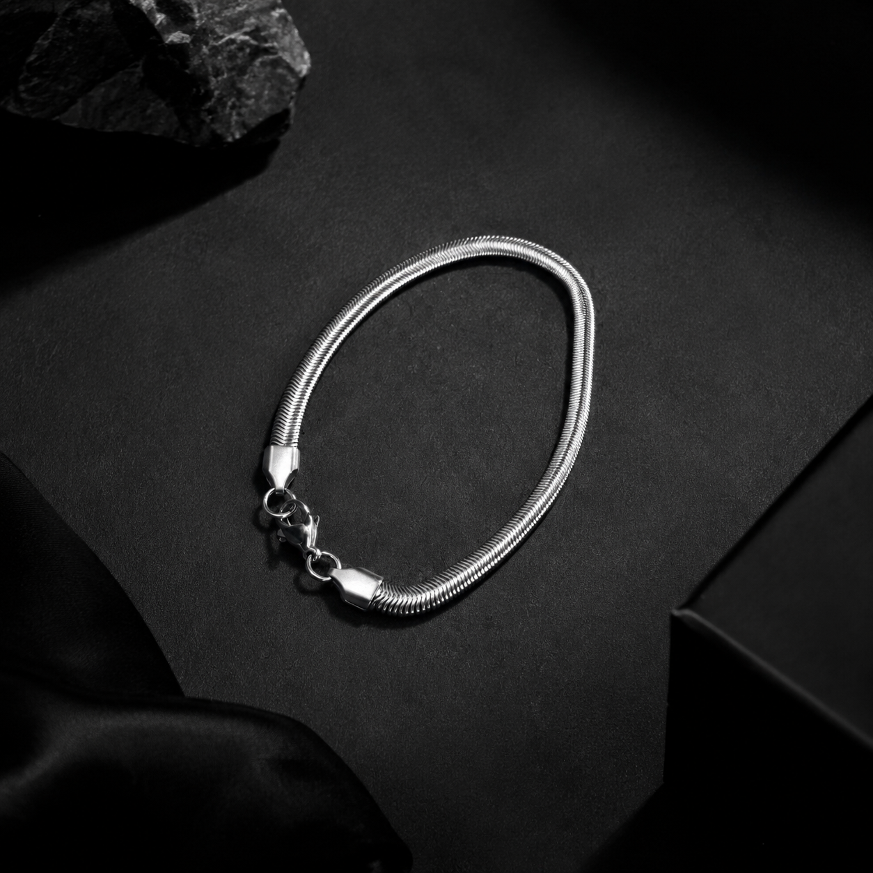Niéche Snake Chain Bracelet flat lay on black background